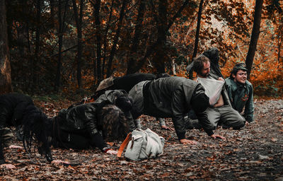 People relaxing in forest during autumn