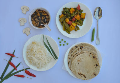 Top view of matar paneer veg, mashroom soup, roti and rice isolated over white background 