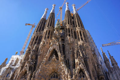 Low angle view of sagrada familia against blue sky