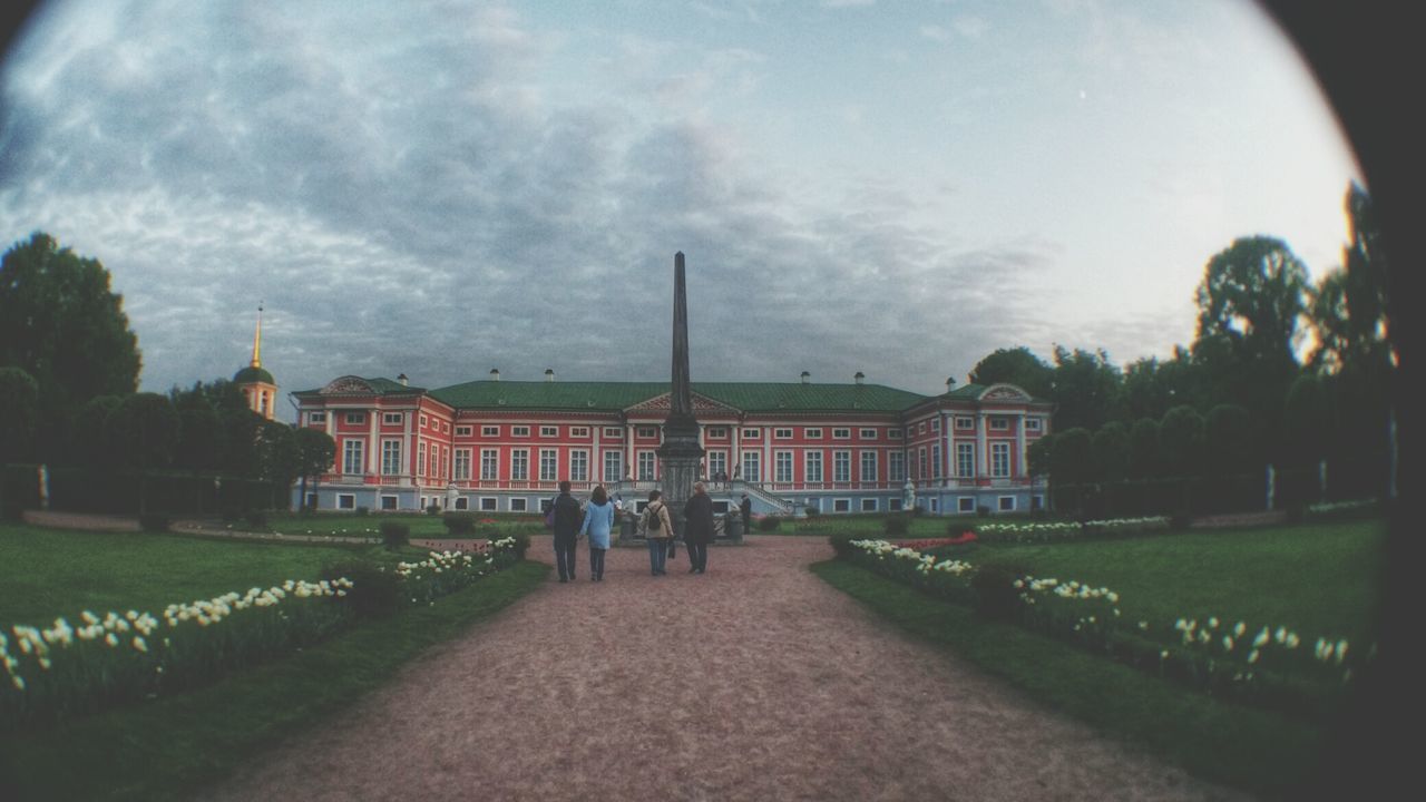 architecture, building exterior, built structure, sky, cloud - sky, grass, tree, men, incidental people, cloud, cloudy, person, walking, lifestyles, outdoors, lawn, street, day, footpath