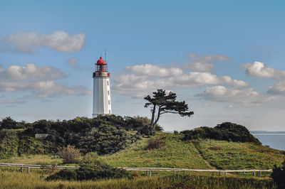 Lighthouse by sea against sky