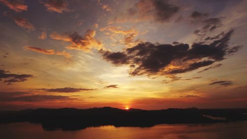 Scenic view of sea against dramatic sky during sunset