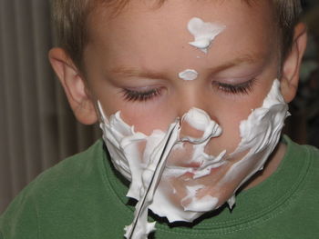 Close-up of boy with shaving cream on face
