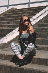 Full length of woman sitting on staircase