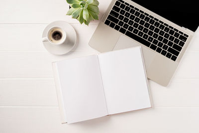 Overhead workspace with laptop and blank book