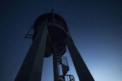 Low angle view of water tower against clear sky at night