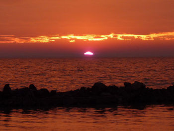 Scenic view of sea against romantic sky at sunset