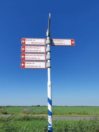 Information sign on field against clear sky
