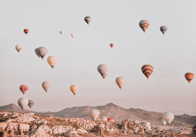 Low angle view of hot air balloons flying against sky