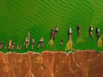 High angle view of boats on sea shore against wall