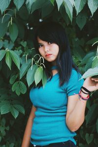 Portrait of a teenage girl in green leaves