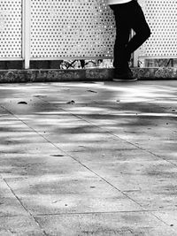 Low section of man standing on sidewalk