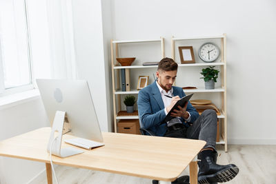 Portrait of young man using laptop at office