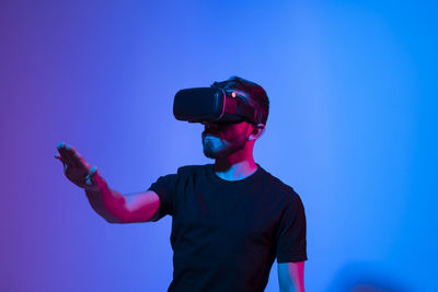 Young man wearing vr against colored background