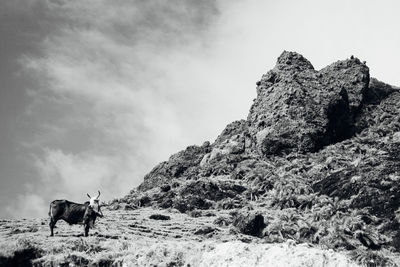 Man standing on mountain against sky