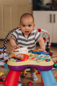 Portrait of boy sitting on table at home