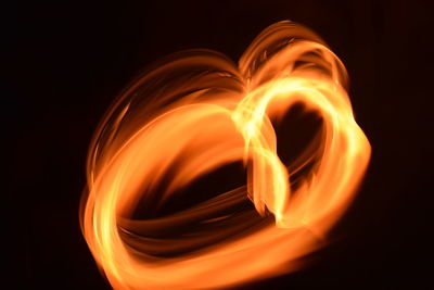 Close-up of lit candle against black background