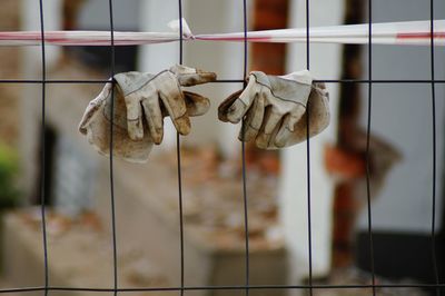 Close-up of dried gloves hanging on grid 