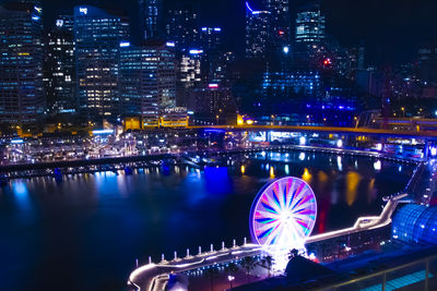 Illuminated bridge over river at night