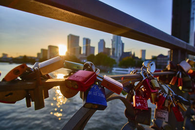 Close-up of padlocks on railing against cityscape