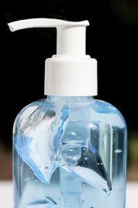 Close-up of water bottle on table against black background