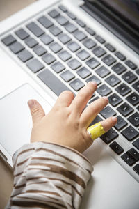 Childs hand on laptop keyboard