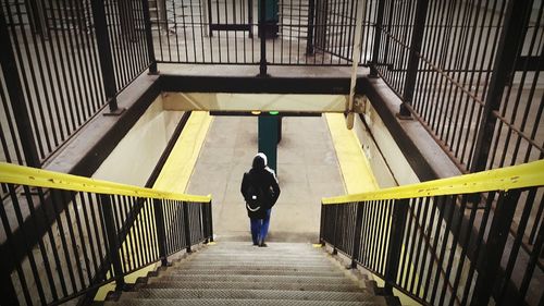 Rear view of person moving down on steps at railroad station