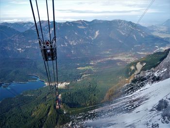 Overhead cable car over snowcapped mountains against sky