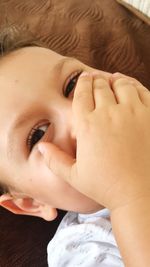 Close-up portrait of boy with hand covering mouth