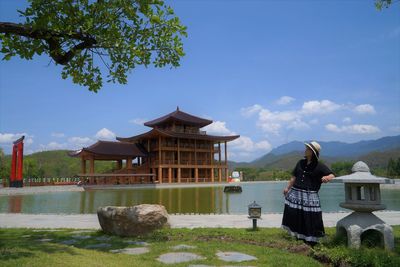 Woman by lake against sky