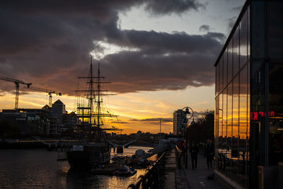 View of harbor against cloudy sky during sunset