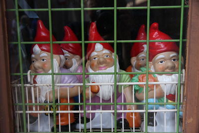 Close-up of dwarf figurines in cage