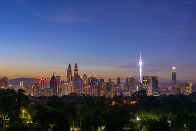 Illuminated buildings in city against sky