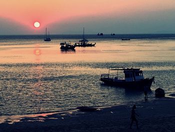 Silhouette boat sailing on sea against sky during sunset