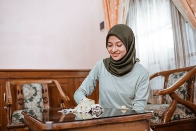 Portrait of young woman sitting at home