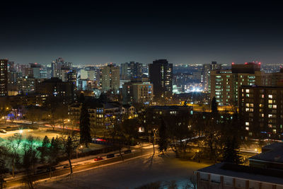 Illuminated cityscape against clear sky at night