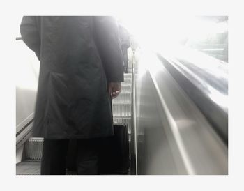 Rear view of man standing at railroad station