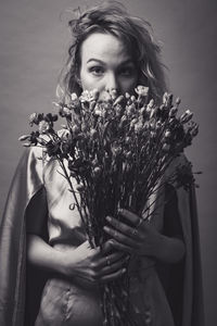 Portrait of beautiful woman against white flowering plants