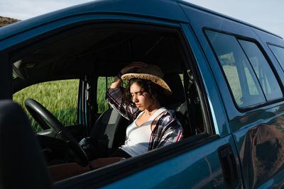 Young woman sitting in car