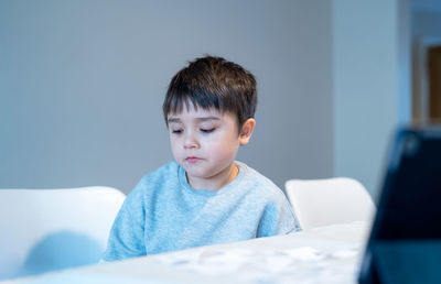 Portrait of boy looking away on table