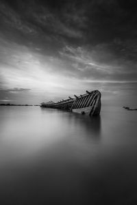 Scenic view of shipwreck sinking at dusk