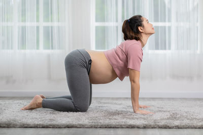 Woman with arms raised on floor