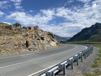 Scenic view of mountain road against cloudy sky