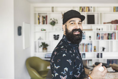 Side view of portrait of happy male architect standing in home office