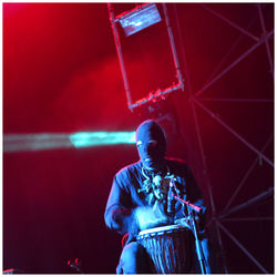 Musician playing djembe during concert at night