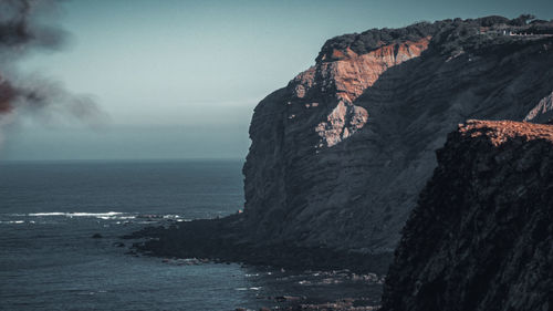 Rock formations by sea against sky