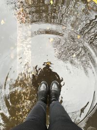 Low section of person standing in water