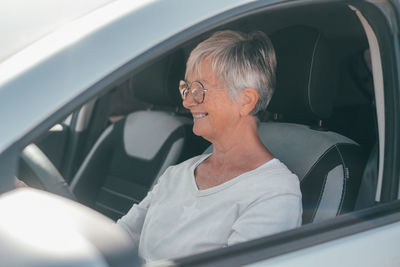 Side view of young woman in car