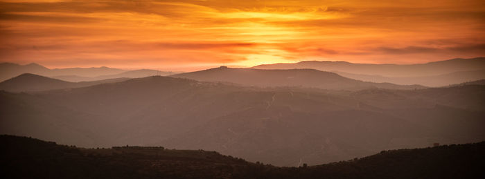 Scenic view of silhouette mountains against sky during sunset