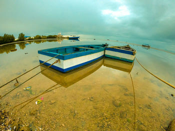 Boat moored in swimming pool against sky